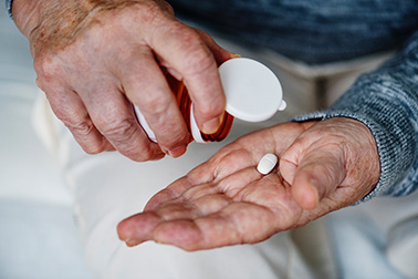 Elderly taking a pill bought from online canadian pharmacy