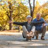 Elderly couple with a woman sitting on skate in the park