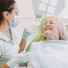 Senior woman smiling with dentist before a tooth extraction while taking Eliquis