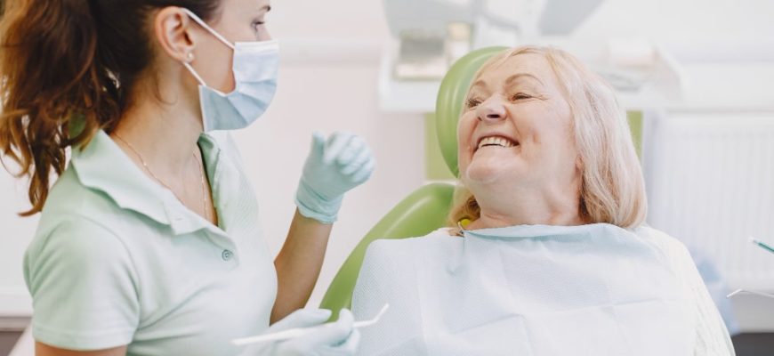 Senior woman smiling with dentist before a tooth extraction while taking Eliquis