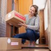 Woman receiving a home delivery package from a Canadian pharmacy, representing safe and reliable access to Eliquis from Canada