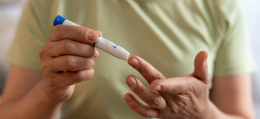 Person checking blood sugar levels with a glucose monitor, representing diabetes management and comparison of Jardiance vs Farxiga treatments.